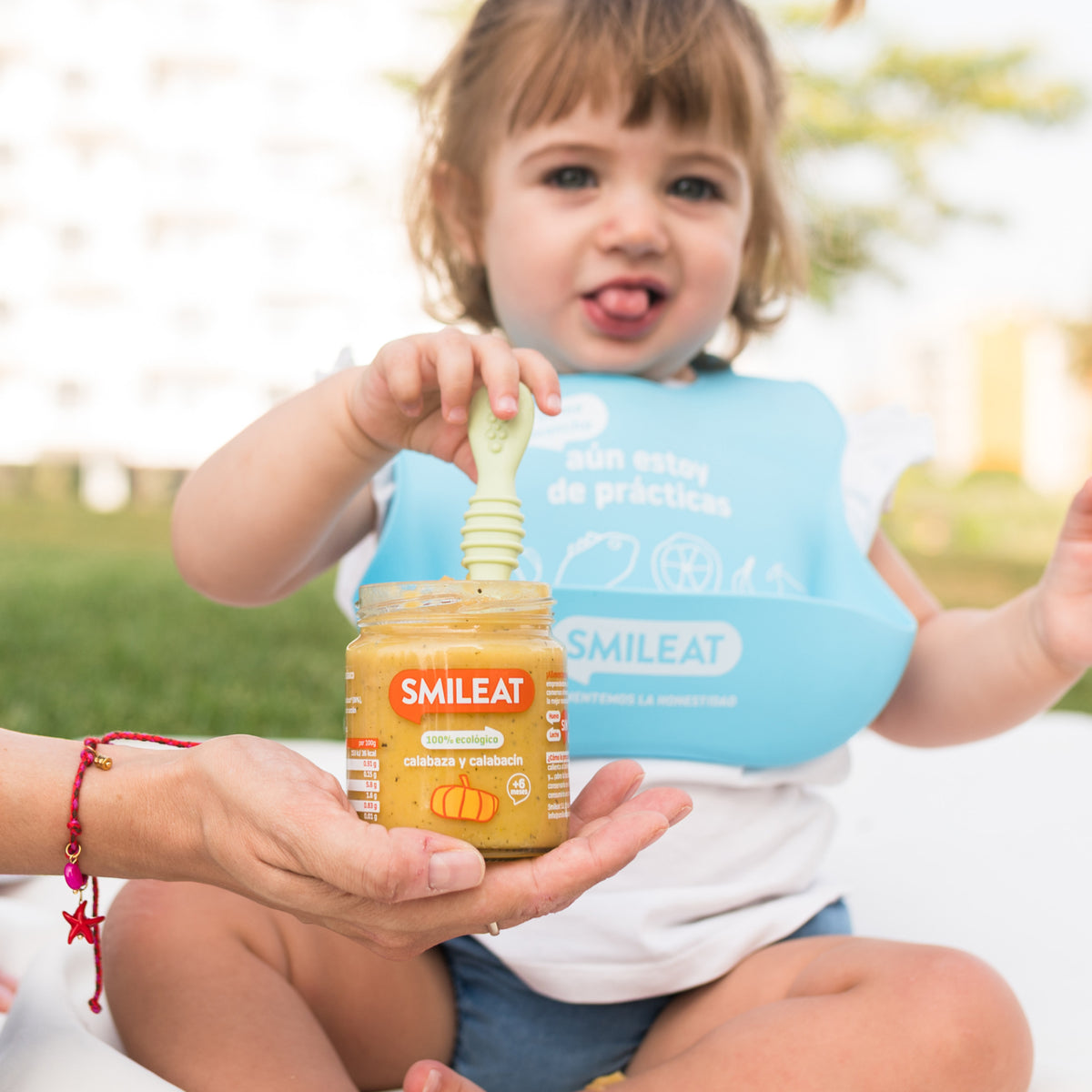 Menina a comer tarrito de legumes biológicos no parque – ingredientes reais da terra