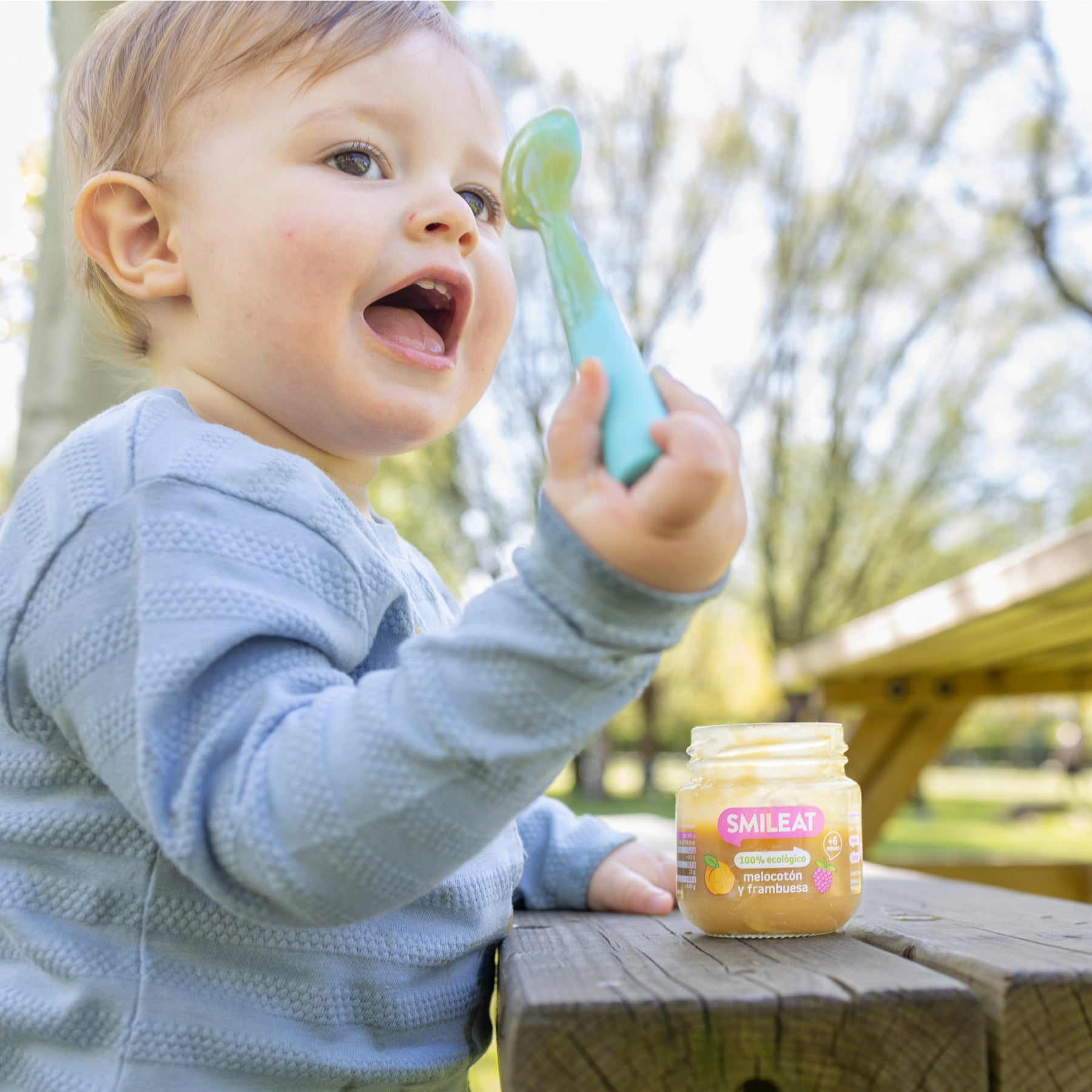 Bebé com colher e tarrito de comida biológica – alimentação infantil com ingredientes honestos