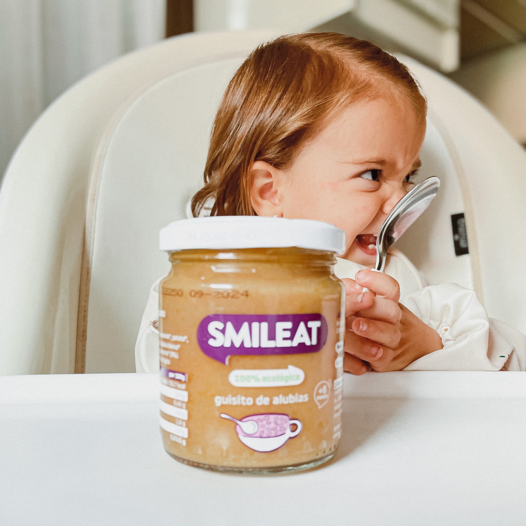 Menina comendo potinho biológico de ensopado de feijão